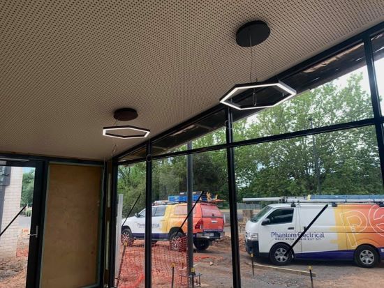 commercial electrician pendant light installation and phantom electrical cars parked behind